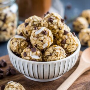 A bowl filled with golden oatmeal energy balls, speckled with chocolate chips and coconut flakes, ready for grabbing.